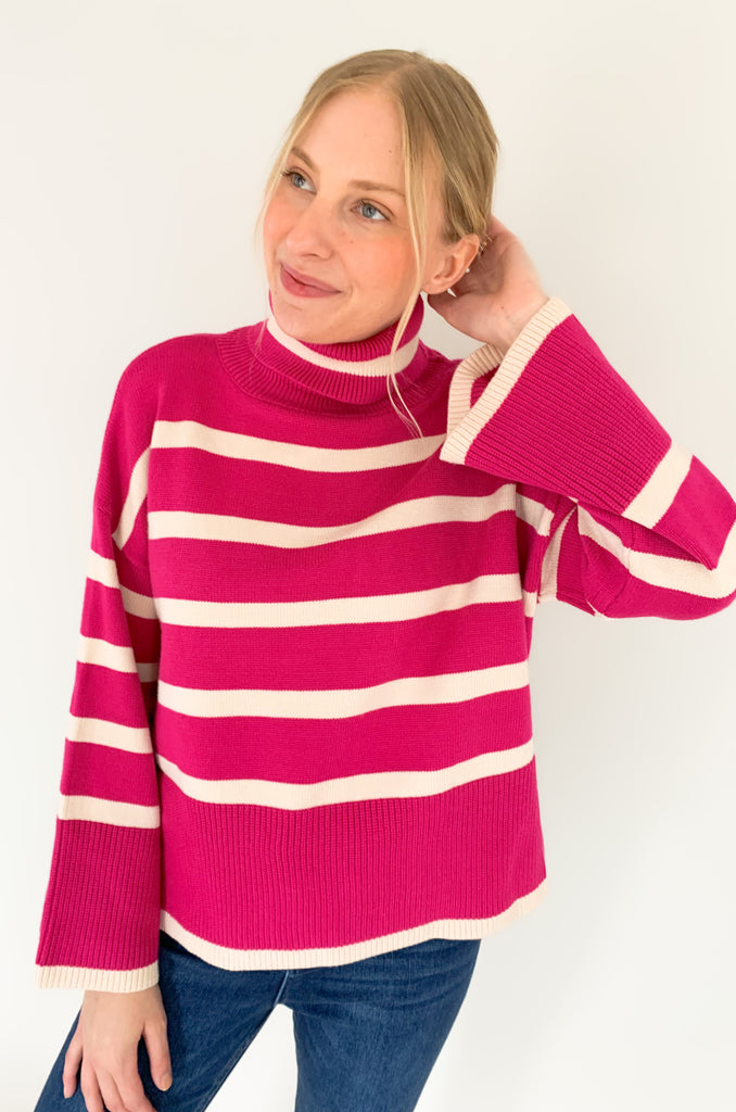 Striped pink or black turtleneck with wide sleeves, flowy body, and side slits in a comfortable knit fabric