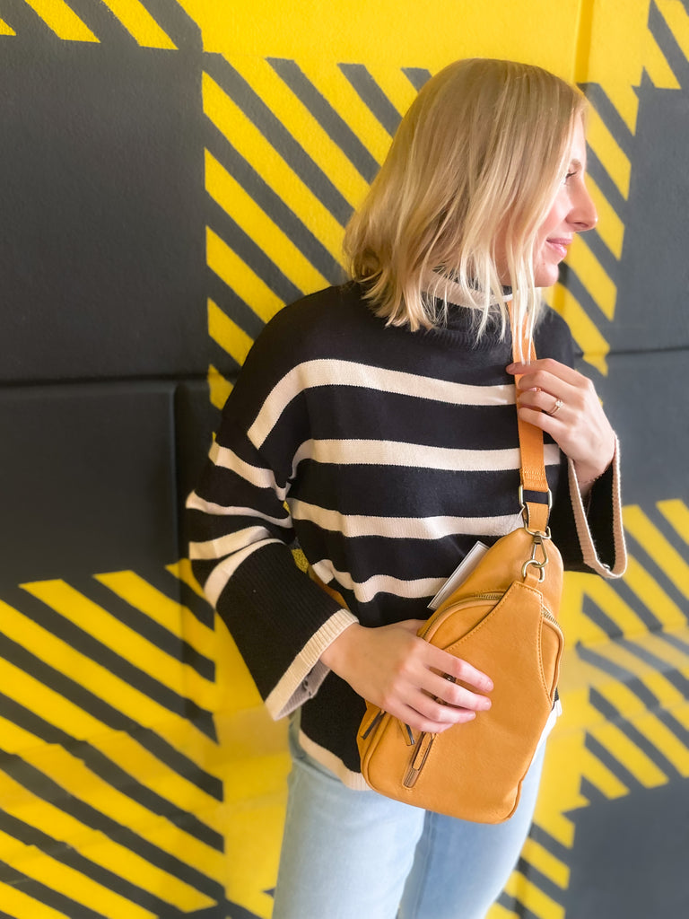 Striped pink or black turtleneck with wide sleeves, flowy body, and side slits in a comfortable knit fabric