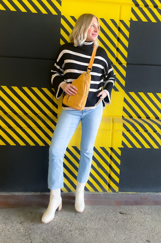 Striped pink or black turtleneck with wide sleeves, flowy body, and side slits in a comfortable knit fabric