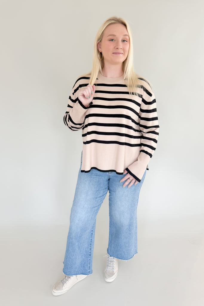 Stay warm and stylish with Suzy Striped Cashmere Sweater. This lightweight sweater features black and beige horizontal stripes, as well as side slits for comfort and an elevated fit and feel. It's a timeless piece than can easily be dressed up or down.  