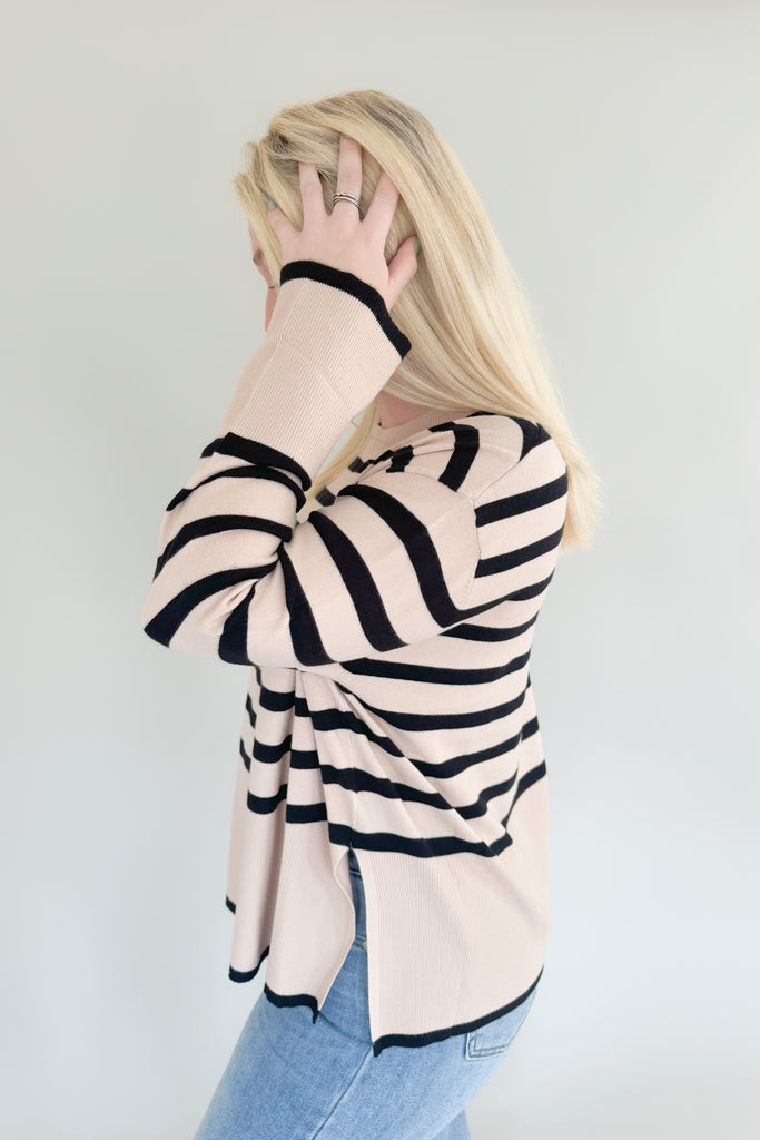 Stay warm and stylish with Suzy Striped Cashmere Sweater. This lightweight sweater features black and beige horizontal stripes, as well as side slits for comfort and an elevated fit and feel. It's a timeless piece than can easily be dressed up or down.  