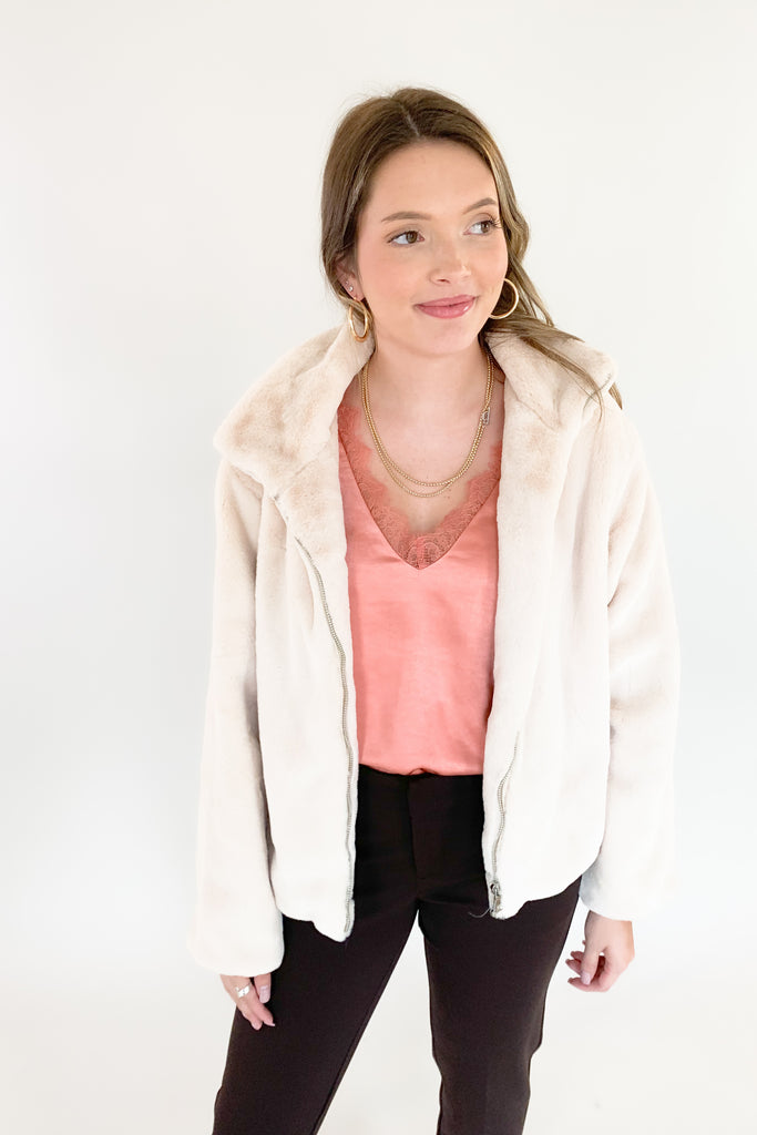 Stay warm and look great in the Teddy Cream Zip Jacket! Soft, creamy teddy material is perfectly paired with a satin lining for a stylish, yet cozy look. The front zip makes it hassle-free and perfect for any holiday occasion. 
