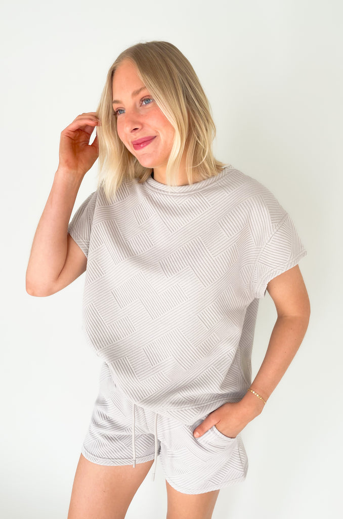 textured round neck short sleeve sweater. Pairs back to matching shorts or cropped wide leg lounge pants. It's the perfect set for comfort and style. 