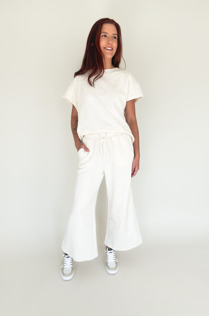 textured round neck short sleeve sweater. Pairs back to matching shorts or cropped wide leg lounge pants. It's the perfect set for comfort and style. 