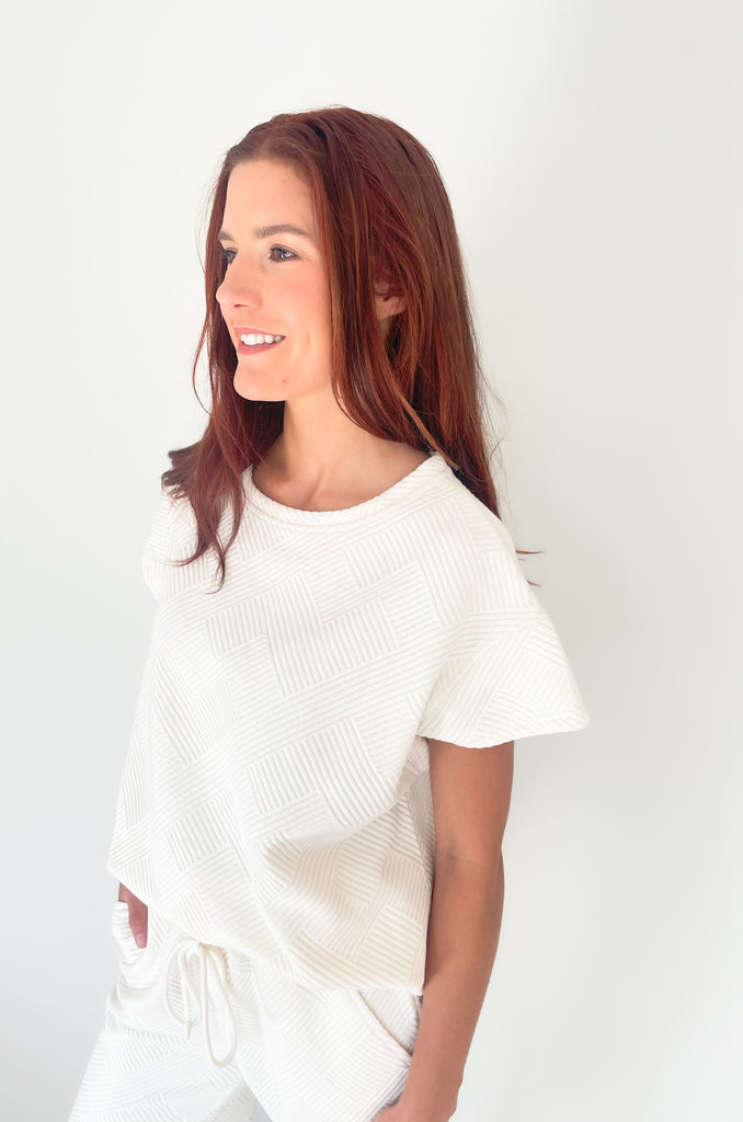 textured round neck short sleeve sweater. Pairs back to matching shorts or cropped wide leg lounge pants. It's the perfect set for comfort and style. 