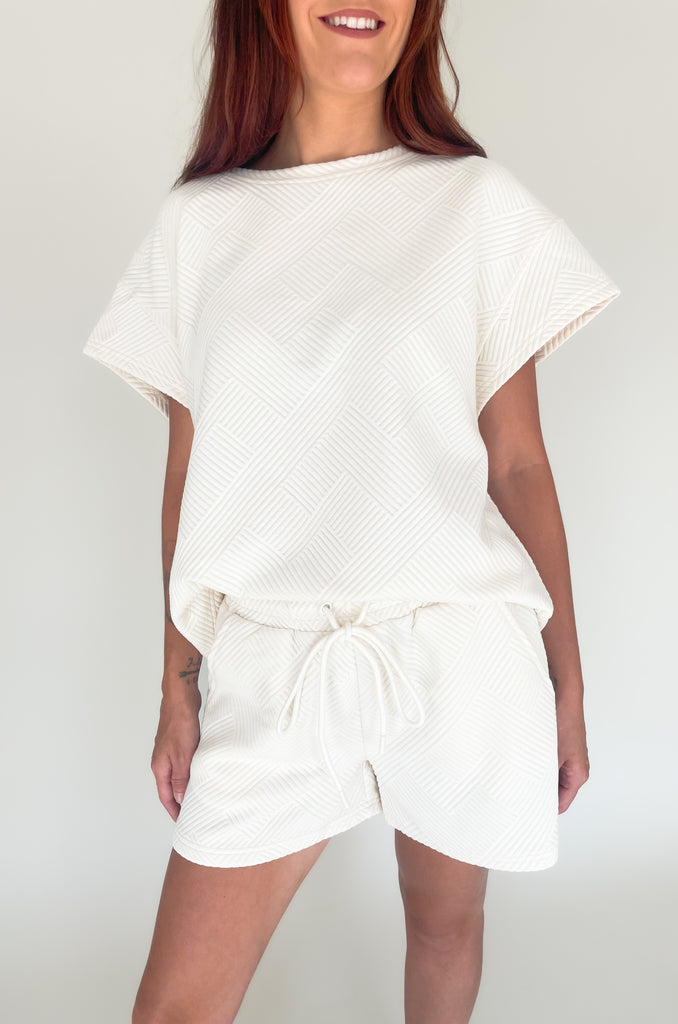 textured round neck short sleeve sweater. Pairs back to matching shorts or cropped wide leg lounge pants. It's the perfect set for comfort and style. 