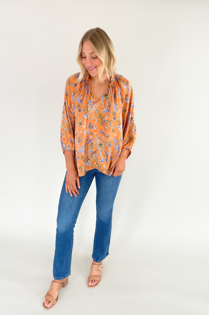 Look your best this summer with our new Tully Floral Blouse! It's elevated and bright with a blue and green floral leaf print. Featuring a ruffle neckline and tassel ties, this blouse creates an eye-catching look