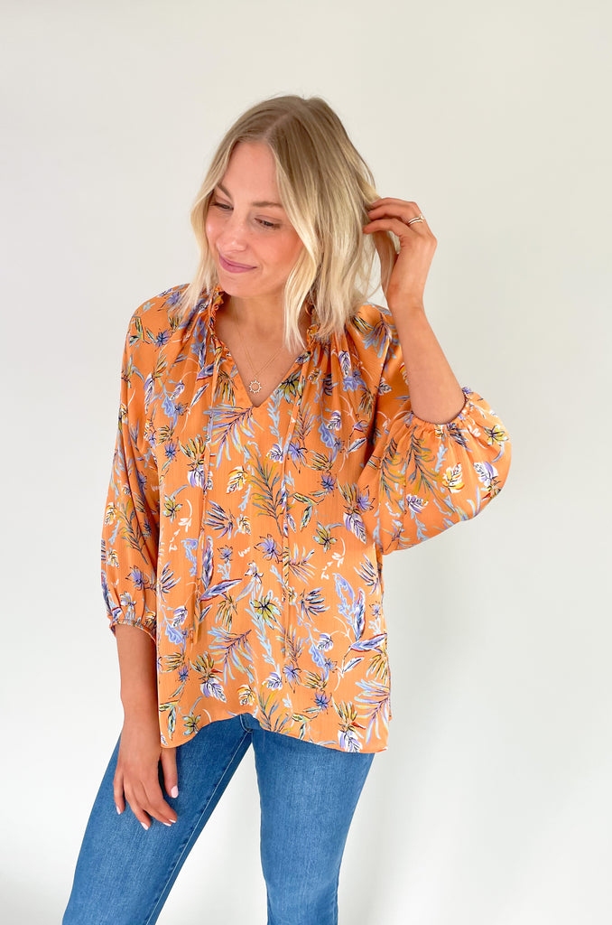 Look your best this summer with our new Tully Floral Blouse! It's elevated and bright with a blue and green floral leaf print. Featuring a ruffle neckline and tassel ties, this blouse creates an eye-catching look