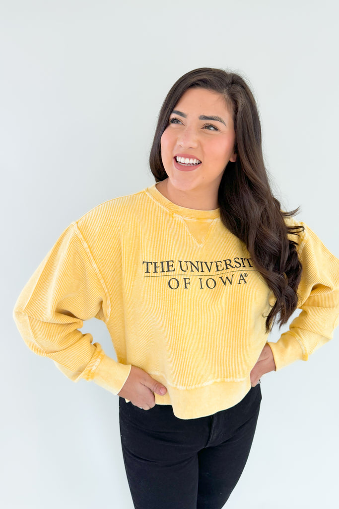 Stay cozy and show your team spirit with this fun University of Iowa Emblem Pullover! It features a unique, bright yellow corded material with block text, making it perfect for fans of the Hawkeyes. Look great and stay comfortable on game day, or snag one of these as a gift!