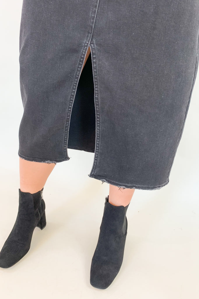 The Vintage Wash Black Denim Midi Skirt is super trendy, but very comfortable for an all denim skirt. The elastic back and lighter weight fabric makes this skirt a go-to for fall! We love the washed black color, front slit, and raw hem, giving this style an edgy look. 