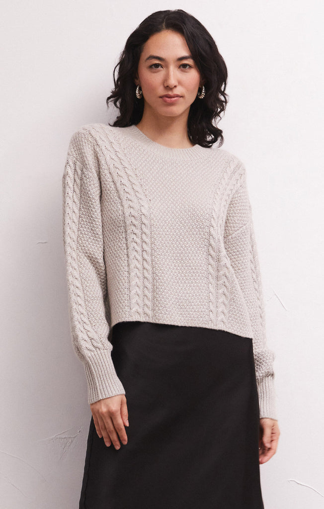 Add some sparkle into your wardrobe this season with this new chunky sweater, made of metallic yarns. The luxe [Z SUPPLY] Eternal Metallic Cable Sweater in Dove has a drop shoulder, crew neckline, and relaxed sleeves that bloussant. This sweater is just as perfect for a night out or a day running errands.