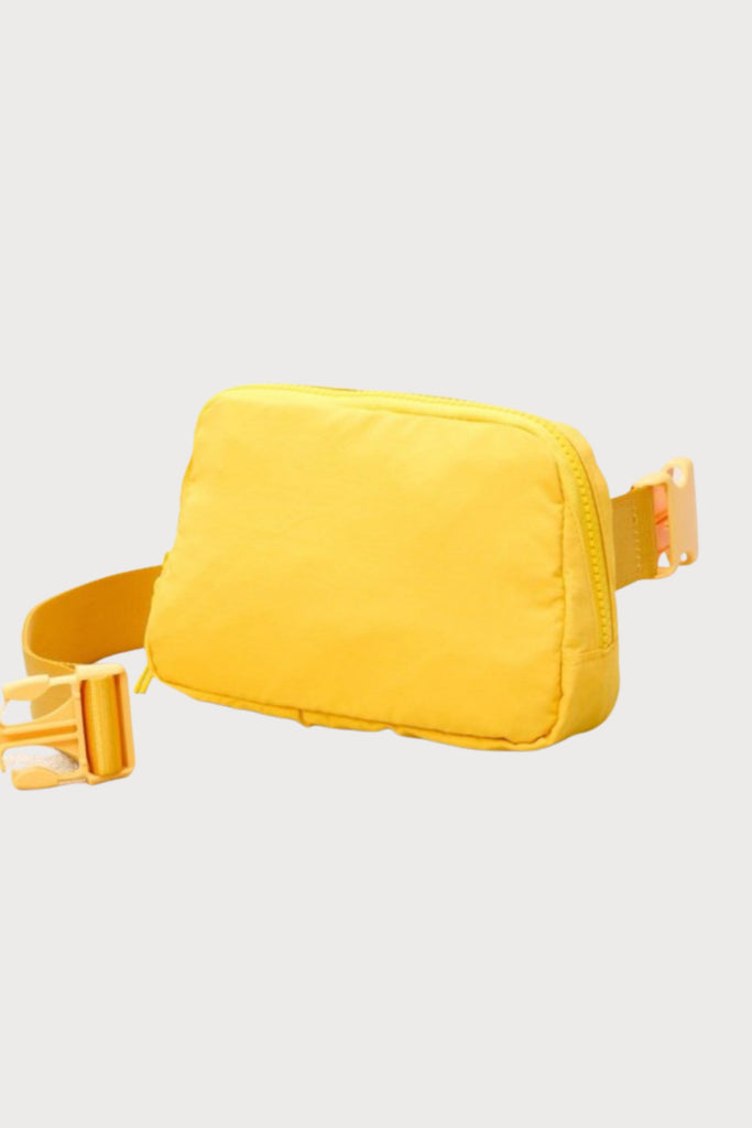 Everyone loves a belt bag for effortless style on the go! This Crossbody Nylon Belt Bag comes in a vibrant yellow with an adjustable strap. The inside is spacious enough to fit your essentials (phone, wallet, keys, etc.) 