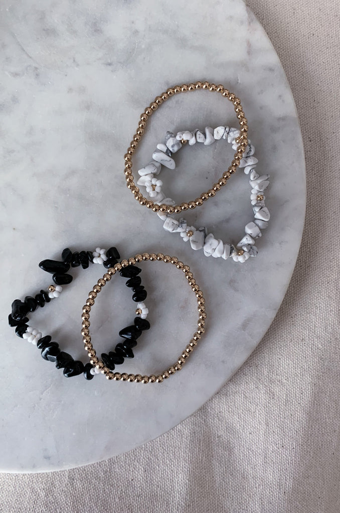 The 2 Strand Stone & Flower Stretch Bracelet is so fun and trendy! Be ready to wear these colorful and stone bead bracelets to parties, school, work, or anywhere! These stretch bracelets can be worn together or separate, totally up to you. Choose between Black, White, or Turquoise.