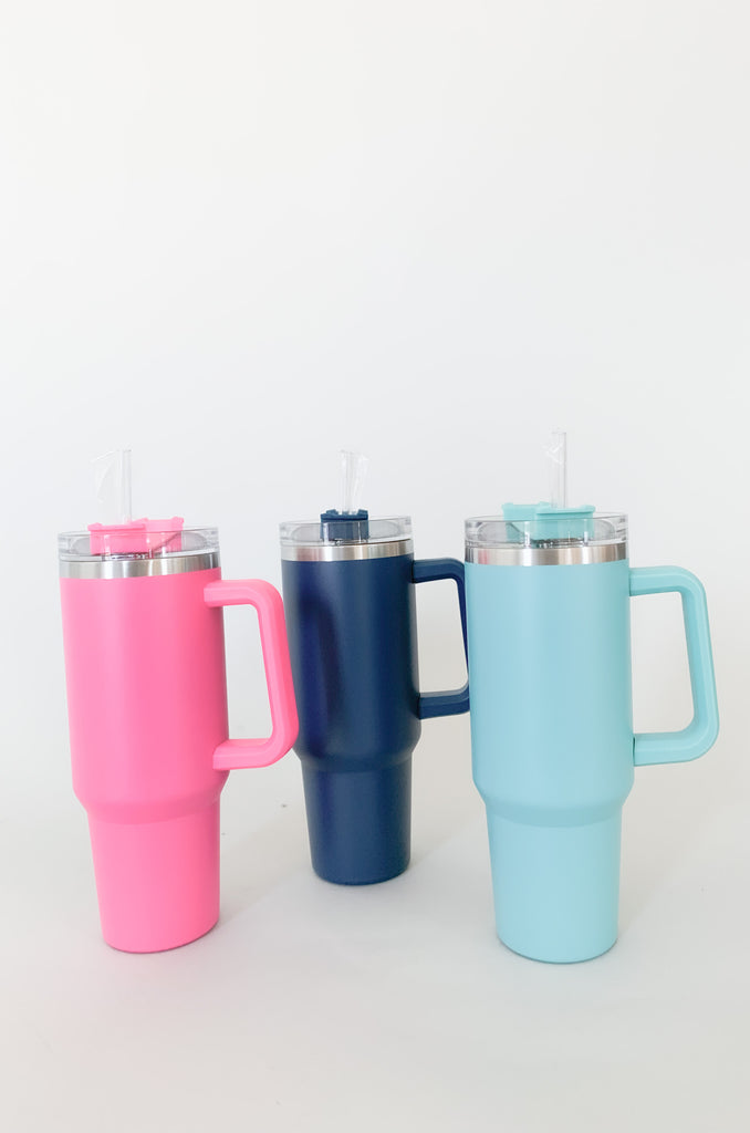 The 40oz Stainless Steel Travel Tumbler is the perfect on-the-go accessory to keep your drinks cold all day long! It's a large size with a comfortable grip handle. The bottom is tapered to fit into your car cup holders. Each bottle comes with a screw on top and plastic straw. Choose between Navy, Aqua, and Hot Pink!