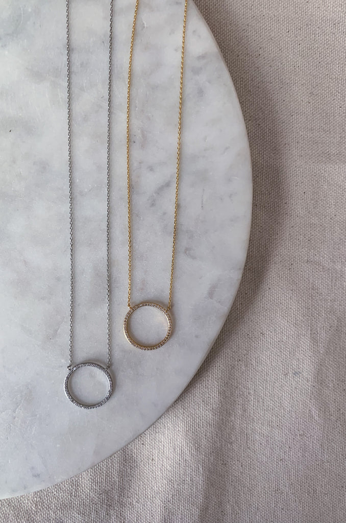 The CZ Medium Circle Necklace is a go to necklace for all seasons. You can wear it to work, school, shopping, or anywhere! This necklace can add some shimmer to any outfit, and is a great choice! 