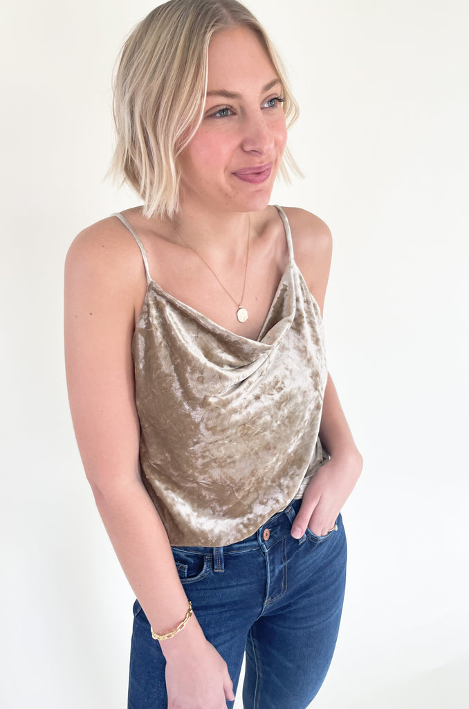 The Champagne Velvet Cowl Neck Cami pairs perfectly with our Make a Toast Velvet Pleated Skirt. You can also pair it with denim like we pictured. It's a versatile, dressy piece that's stunning for the holiday season. It has a crushed velvet look that's trendy too!
