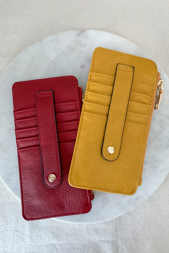 The Fay Slim Wallet with Snap Closure is so cute and convenient! They are slim, but have lots of compartments. You can easily store all of your cards, ID, receipts, and more. These are made with the softest vegan leather too.