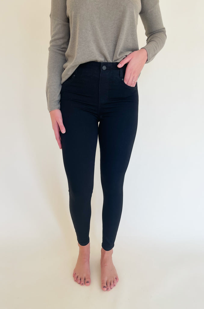 The Gia Glider Pull On Ankle Pants 30" are a black classic skinny jean. The color is perfect for fall and winter, but can really be worn all year long. They are a pull on elastic pant built for comfort. Soft and stretchy doesn't even begin to describe how amazing these pants are! It does not have a zipper, which makes the style look streamlined. You can wear these jeans with any top, blouse, or sweater. They will instantly elevate the look. Try a similar style in Java brown too! 