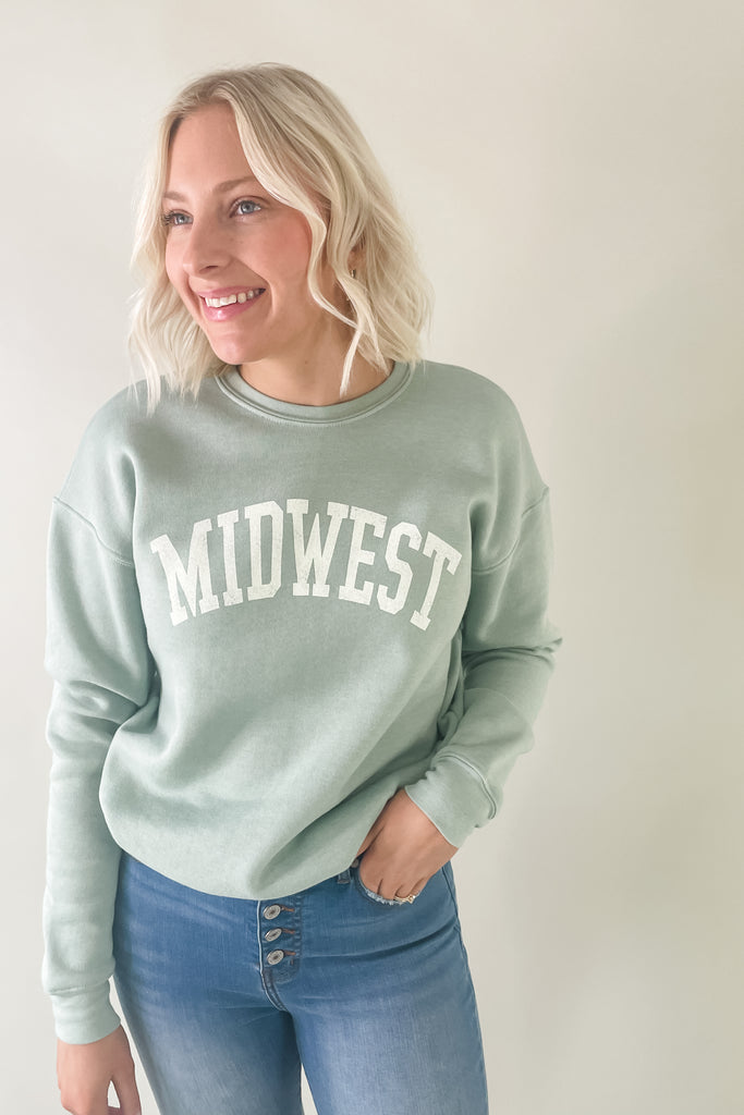 The Midwest Fleece Graphic Pullover is perfect for every midwest gal on-the-go! The Midwest print is slightly faded, giving it a vintage look. It has your classic crewneck shape with a round neckline, cuffed sleeves, and a cuffed hem. The inside is super soft, keeping you cozy on chilly days. It comes in several colors too!!