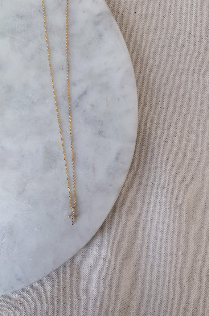 The Mini Cross Gold Necklace is the perfect gift for someone else, or for yourself! This style has a 1/2" Cross pendant that is filled with gorgeous gems that catch the light in a beautiful way. It's an everyday staple.