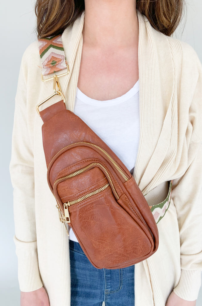 The Riley Sling Guitar Strap Handbag is one of our new favorites for on-the-go! It is so easy to carry with plenty of storage to fit all of the essentials. It has one large compartment that can fit your phone, a small water bottle, keys, you name it. There are two additional smaller compartments for sunglasses or your wallet. Plus, these straps are detachable. Add one of our fabric guitar straps to customize your look!