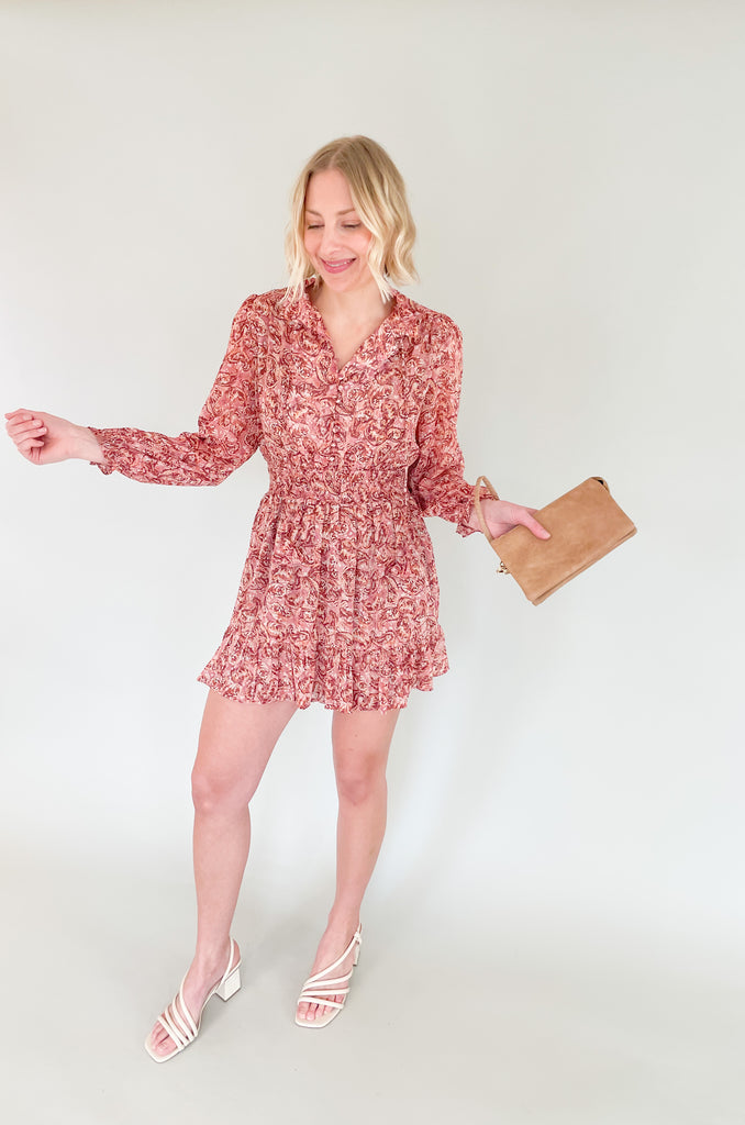 The Sangria Cinched Waist Long Sleeve Dress is so pretty and fun! We love the dusty pink floral print and feminine details- it has all! The top has a preppy collar with buttons and tassel ties. The waistband is elastic with a little flounce. Wear this dress to all of your spring and summer events for an effortless look! 