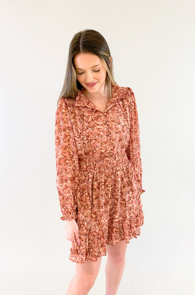 The Sangria Cinched Waist Long Sleeve Dress is so pretty and fun! We love the dusty pink floral print and feminine details- it has all! The top has a preppy collar with buttons and tassel ties. The waistband is elastic with a little flounce. Wear this dress to all of your spring and summer events for an effortless look! 