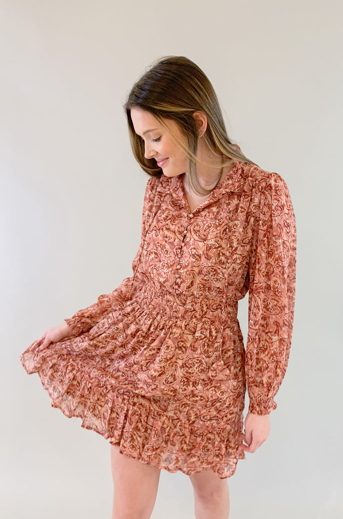 The Sangria Cinched Waist Long Sleeve Dress is so pretty and fun! We love the dusty pink floral print and feminine details- it has all! The top has a preppy collar with buttons and tassel ties. The waistband is elastic with a little flounce. Wear this dress to all of your spring and summer events for an effortless look! 